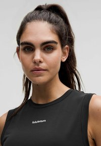 Czarny bezrękawnik sportowy o gładkiej strukturze i okrągłym dekolcie, z białym logo lululemon umieszczonym na środku klatki piersiowej.