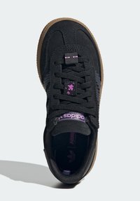 Sneaker nera in pelle scamosciata e mesh, dotata di chiusura con lacci, dettagli viola, collo imbottito e suola in gomma color gomma.