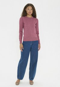 Maglione color bacca, texture a maglia, scollatura a girocollo. Abbinato a jeans in denim blu con vestibilità comoda, design a gamba dritta.
