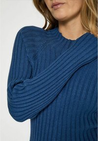 Maglione a costine di colore blu profondo, con maniche lunghe e una finitura testurizzata. Il collo presenta un delicato bordo a scallop.