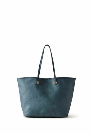 Sac cabas en cuir texturé bleu foncé avec deux fines bretelles et des détails de boutons métalliques ronds sur fond blanc.