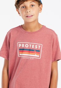 Rode heidelook korte mouwen t-shirt met een grafische print waarin het woord "PROTEST" en kleurrijke golven zijn afgebeeld. Casual pasvorm; zachte katoenmateriaal.