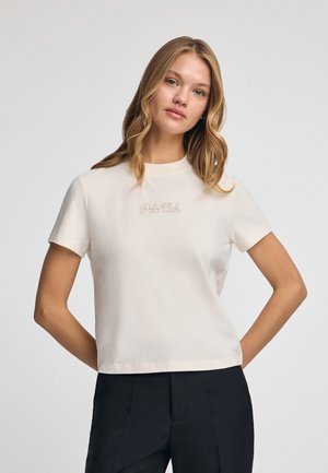 Korte mouw crèmekleurig T-shirt van katoen, met discreete "Polo Club" borduursel in cursief lettertype op de borst. Eenvoudig ontwerp, reguliere pasvorm.