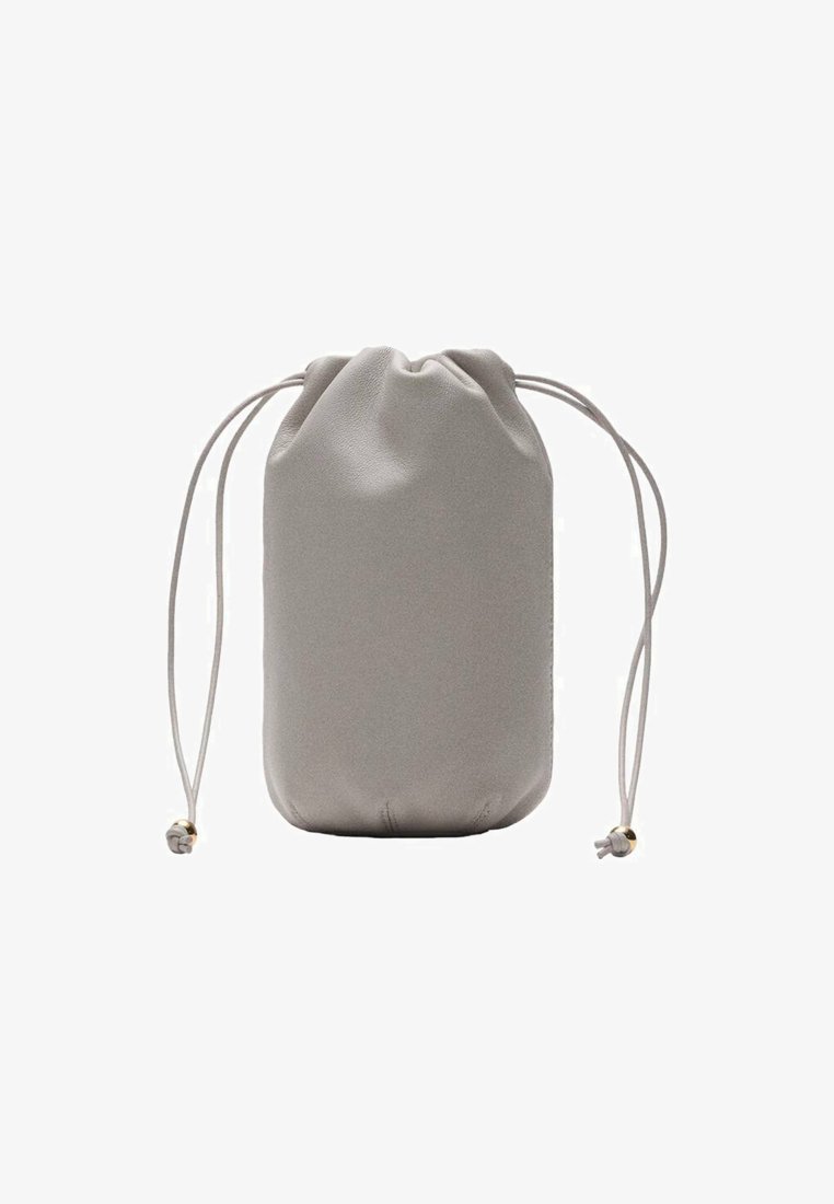 Šedý sáček na šňůrku vyrobený z hladké tkaniny. Cylindrický tvar se staženým vrškem a dvěma dlouhými šňůrkami s malými zlatými akcenty.