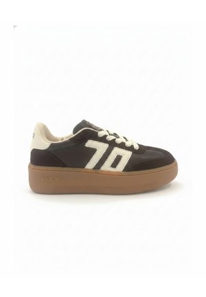 Zapatilla baja con parte superior en blanco y negro, cordones blancos, gran "70" en el lateral y suela gruesa marrón etiquetada con "BLACK 70."