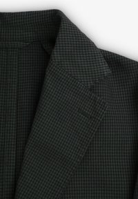 Chaqueta de patrón houndstooth en verde oscuro con solapa, textura suave y un corte ajustado que cuenta con un solo bolsillo.