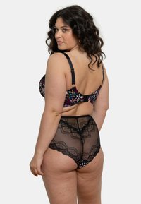 Culotte en dentelle noire avec une ceinture florale, présentant une texture translucide et des bords festonnés. Soutien-gorge noir à motif floral assorti avec des bretelles réglables.