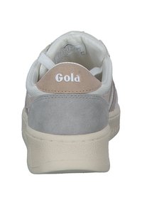 Sneaker bianca con tallone in suede grigio e dettagli in pelle color marrone. Logo "Gola" visibile sul tallone. Suola in gomma testurizzata. Design casual.