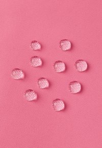 Rosa strukturierte Oberfläche mit mehreren Wassertropfen, die eine glatte Oberfläche und ein Muster aus kleinen, erhöhten Punkten darunter zeigt.