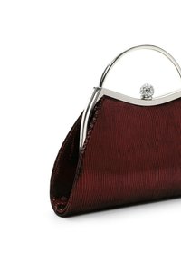 Sac à main texturé rouge foncé avec monture en métal argenté et fermoir rond orné de bijoux, présenté sur fond blanc.