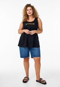 Schwarzes ärmelloses Top mit dem Schriftzug "Sunkissed" in Gold, kombiniert mit Jeansshorts und Sandalen mit Leopardenmuster. Glattes Material, lässiger Schnitt.