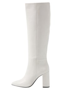 Botas blancas hasta la rodilla hechas de cuero suave, con puntera puntiaguda y un grueso tacón cuadrado para estabilidad y soporte.
