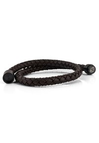 Pulsera trenzada de cuero marrón con extremos negros redondeados, que presenta un sutil detalle del logo en uno de los extremos y una superficie suave y texturizada.