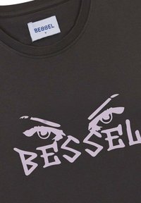 Camiseta negra con texto gráfico en rosa e ilustraciones de ojos, cuello redondo y tejido de algodón suave con una textura lisa.