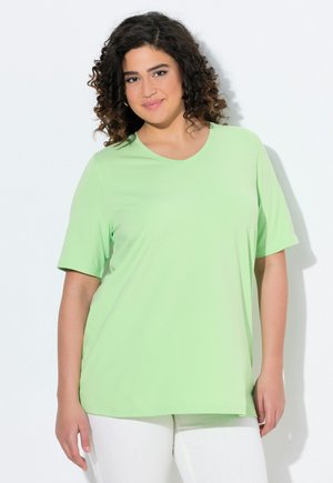 Lichtgroene korte mouwen t-shirt met een V-hals en een zachte, gladde textuur. De pasvorm is relaxed en het wordt gecombineerd met witte broek.