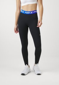 Crne tajice s plavim Nike Pro pojasom, s prilagođenim dizajnom i glatkom teksturom. Mali Nike logo na donjem dijelu noge.