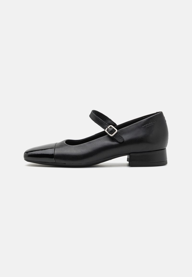 Chaussures Mary Jane en cuir noir avec un embout en vernis, une sangle cheville réglable et un petit talon carré. Texture lisse et design élégant.