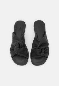Svarta slidensandaler har en knuten design på ovansidan. Tillverkade av mjukt material med en slät yta och platta sulor.