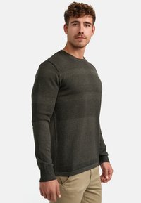 Maglione verde scuro con righe orizzontali texturizzate, colletto rotondo e maniche lunghe. Realizzato in materiale a maglia. Vestibilità casual.