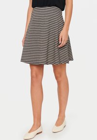 Svartvit rutig kjol med veck, tillverkad av lätt tyg, knälång, med en figurnära midja och svängig nederkant.