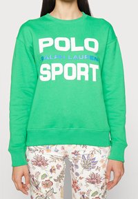 Sudadera verde con texto grande en blanco y azul que dice "POLO RALPH LAUREN SPORT", con puños y dobladillo acanalados.