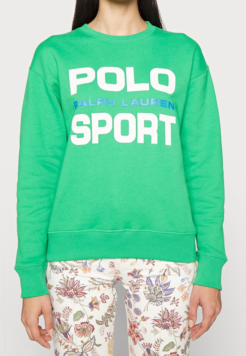 Sudadera verde con texto grande en blanco y azul que dice "POLO RALPH LAUREN SPORT", con puños y dobladillo acanalados.