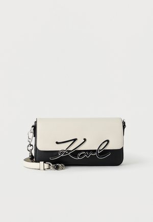 Rechteckige schwarz-weiße Crossbody-Tasche mit silberner Kette und „Karl“-Schriftzug auf der Vorderklappe.