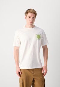 White cotton t-shirt with short sleeves, featuring a green graphic and text design on the left chest area. Simple crew neck style.