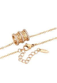 Gouden armband met een gemarmerde kraal met heldere kristallen, verbonden door een ketting met een kreeftsluiter en label.
