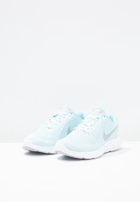 Světle modré sportovní boty s mesh svrškem, bílé podešve a stříbrným logem Nike. Disponují šněrovacím uzávěrem a texturovanou oporou paty.