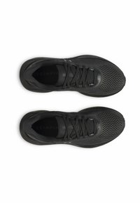 Chaussures de sport noires avec une tige en maille respirante, des lacets plats et une semelle texturée. Le design est élégant avec des accents de marque subtils.