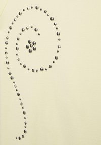 Kis kerek és négyzet alakú fémes szegek spirálmintában világos bézs szövetfelszínen.