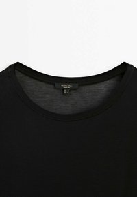 T-shirt noir en coton à col rond avec une étiquette Massimo Dutti indiquant la taille S en tailles européenne, américaine et mexicaine.