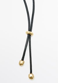 Zwarte leren halsketting met twee gouden metalen accenten en een gouden knoopdetail in het midden, met een gladde textuur en een onderscheidende vorm.