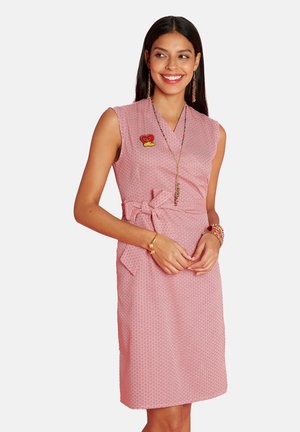 Rosa Kleid mit geometrischem Muster, ärmelloses Design, Wickel-Front, gebundener Taillengürtel und zwei Seitentaschen. Mit einer herzförmigen Brosche.