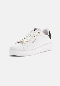 Białe skórzane sneakersy z złotym wykończeniem, okrągłym noskiem i grubą gumową podeszwą. Posiadają logo na boku oraz wzorzysty akcent na pięcie.