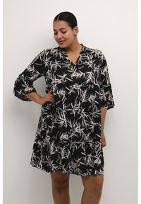 Schwarzes Kleid mit weißem Bambusblattmuster, V-Ausschnitt und drei Viertel langen Glockenärmel, mit einem gestuften Rock und weichem, strukturiertem Stoff.