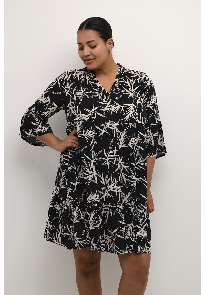 Schwarzes Kleid mit weißem Bambusblattmuster, V-Ausschnitt und drei Viertel langen Glockenärmel, mit einem gestuften Rock und weichem, strukturiertem Stoff.