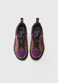 Sapatos de caminhada roxos e cor-de-rosa com solas de borracha pretas, apresentando atacadores pretos, tecido texturizado e uma etiqueta de logotipo no calcanhar.