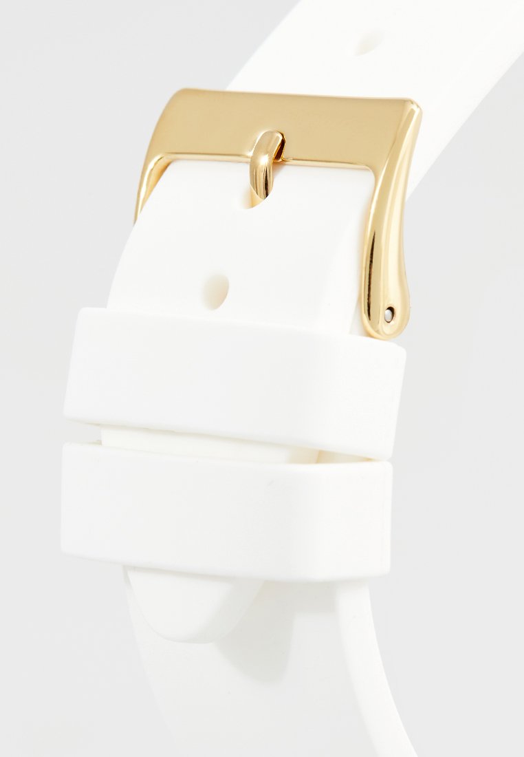Bracelet de montre en silicone blanc avec une boucle en métal doré et une finition lisse ; conçu avec des trous réglables pour le dimensionnement.