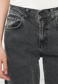 Høyt liv sorte denim jeans med en falmet finish, som har frontlommer, knapplukking og kontrasterende sømdetaljer.