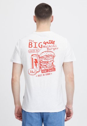 Camiseta blanca de algodón con un diseño gráfico rojo de una hamburguesa y un refresco, con el texto "La GRAN Hamburguesa Waikiki" y "HECHA EN CASA, LA MEJOR DE LA CIUDAD."