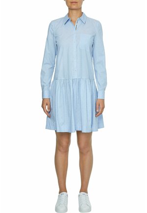 Lyseblå skjortekjole med knapper foran, krave, lange ærmer og en rynket nederdel. Diskret stribet mønster og lommefunktion.