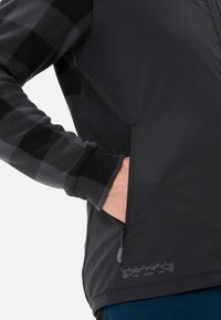 Gilet in pile nero con maniche a fantasia plaid, dotato di tasca con zip e dettagli testuali all'orlo, morbido al tatto.