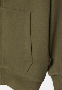 Olivengroene hoodie met een ritssluiting, geribde manchetten en een voorzak. Zachte textuur met zichtbare stiksels bij de zak.