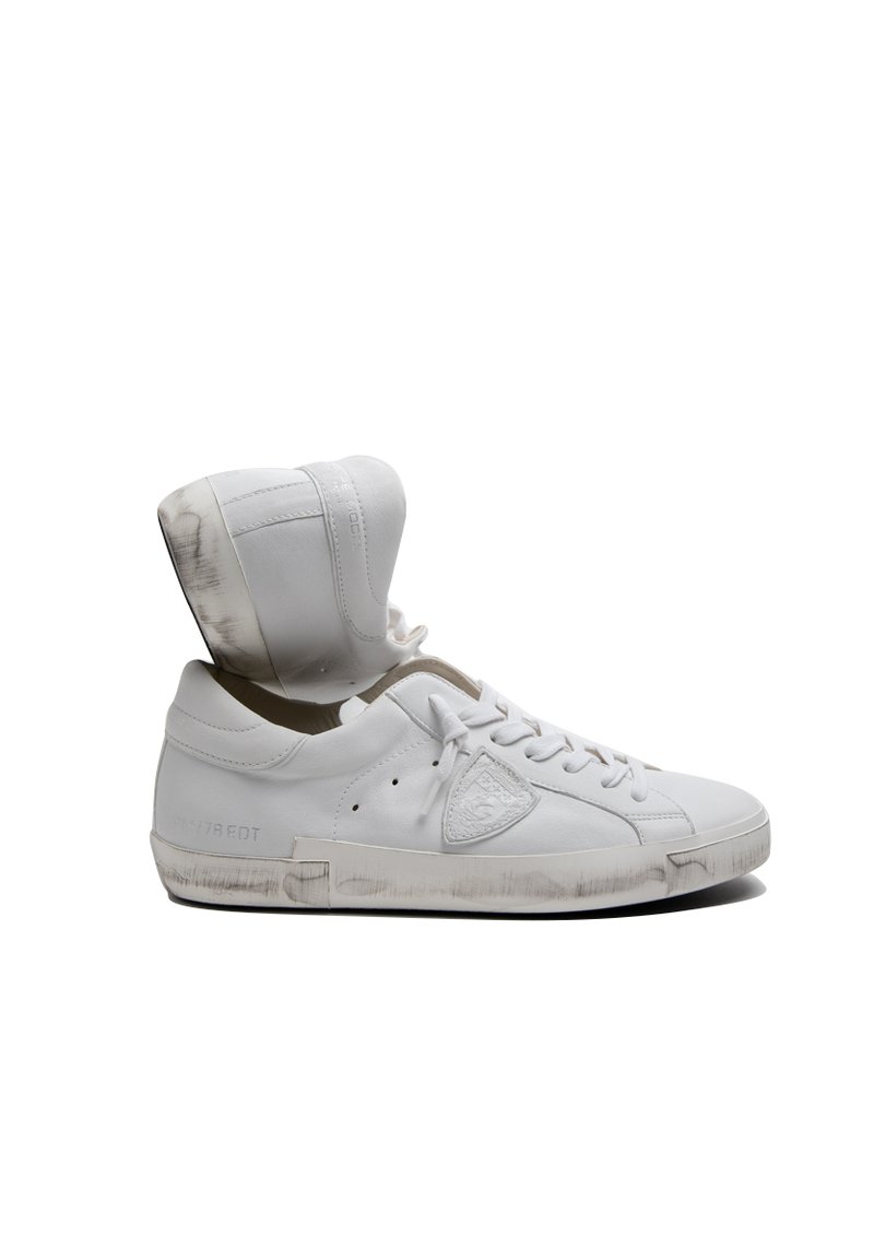 Basket en cuir blanc avec un design montante. Présente un bout rond, un laçage à l'avant et une semelle légèrement usée. Le revers intérieur est de couleur beige clair.