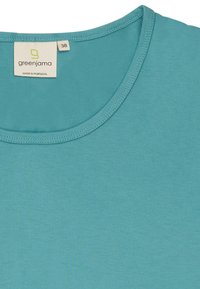 T-shirt turchese a maniche corte con scollo rotondo. Tessuto morbido. Etichetta con la scritta "greenjama" e taglia "38." Prodotto in Portogallo.