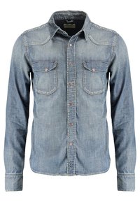 Ljusblå denimskjorta med långa ärmar, två bröstfickor, tryckknappar och en spetsig krage. Har en blekt textur och klassisk design.