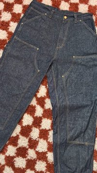 Τζιν παντελόνι με σκούρο μπλε απόχρωση, με πολλαπλές μπροστινές τσέπες, κίτρινη ραφή και κούμπωμα με κουμπί. Καθαρός σχεδιασμός, χωρίς σχέδια.