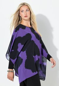 Violetti poncho mustalla abstraktilla kuviolla, väljällä mallilla ja laskeutuvalla kankaalla. Siinä on pitkät hihat ja pyöreä pääntie.